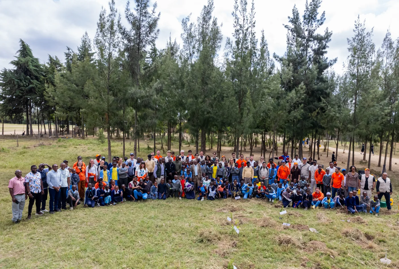 Groepsfoto van deelnemers en lokale bewoners bij een aanplantdag op een natuurherstelterrein